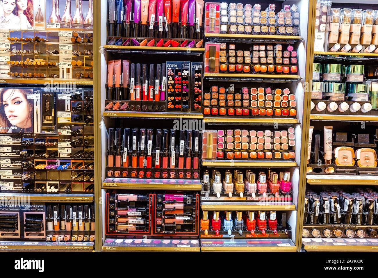 Lipsticks, lip liners and makeup essentials arranged on shelves